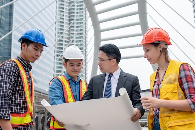 Treffen und Diskussion von Geschäftsmann, Ingenieur und Konstrukteur mit Planpapier für Bauprojekt in der Stadt