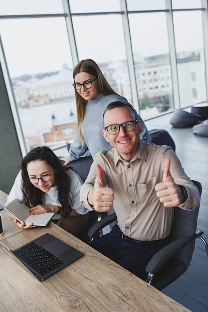 Treffen von Büroangestellten am Computer. Kreativteam teilt Laptop im Büro, bespricht Startup-Präsentationsdesign-Projekt und diskutiert Ideen, während es redet