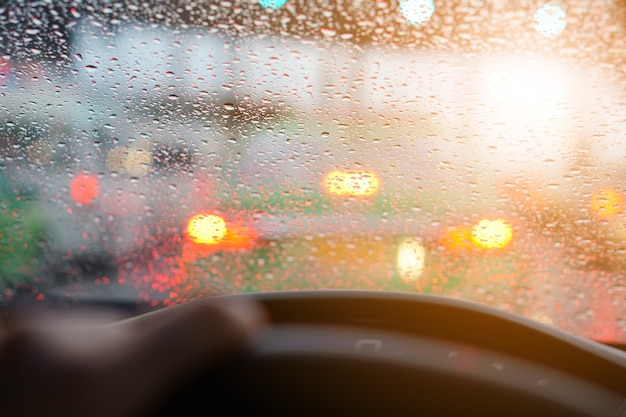 treibendes Auto und Wassertropfen auf Auto Spiegel mit Regen und Stau auf der Schnellstraße