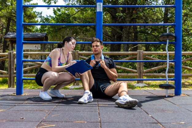 Treinador de fitness que presta consultoria a clientes ao ar livre