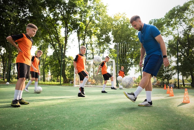 Foto treinador de futebol ensinando seus alunos