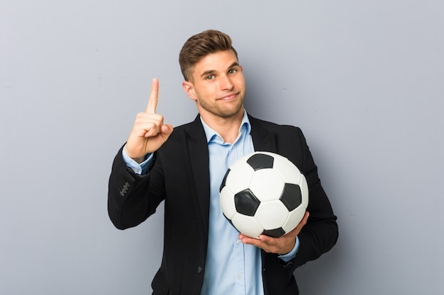 Treinador de futebol jovem mostrando o número um com o dedo.