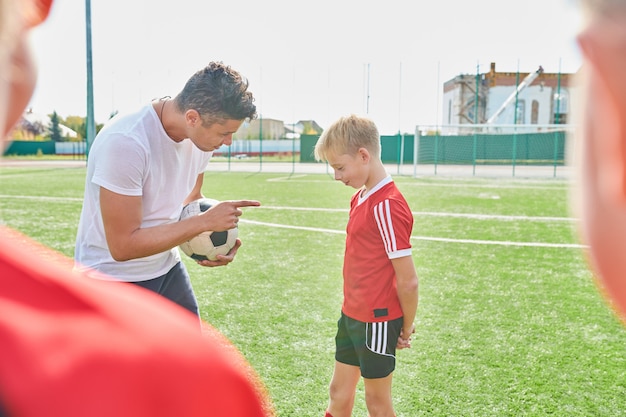 Treinador de futebol, motivando o menino