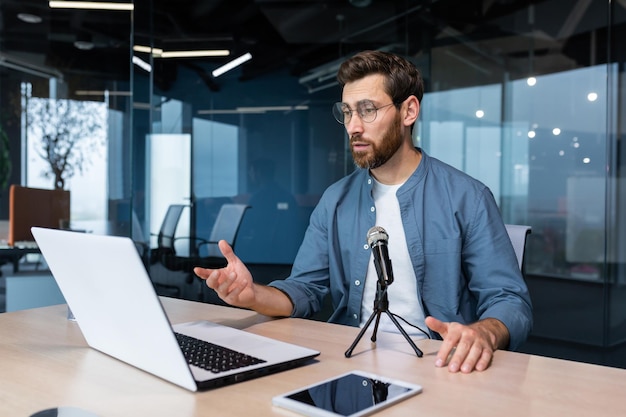 Treinador de negócios dentro do escritório gravando o empresário de podcast de áudio trabalhando no laptop usando