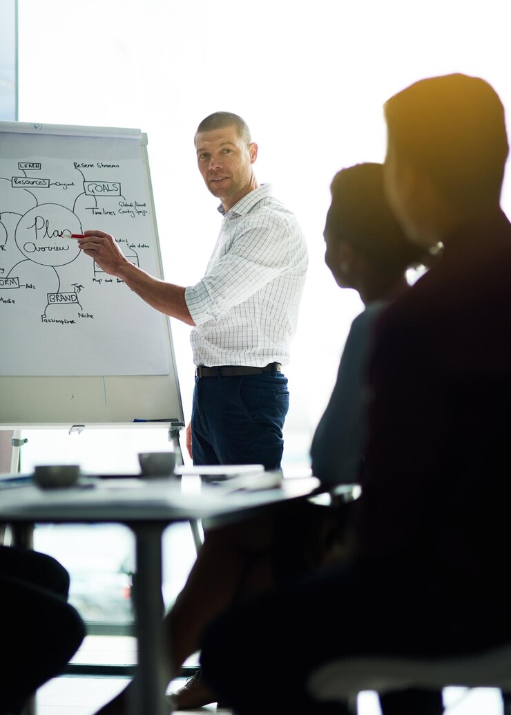 Foto treinador de negócios e escrita com quadro branco para apresentação de reuniões ou treinamento de pessoal no escritório homem falando com um grupo de funcionários para discussão de brainstorming ou ideias sobre projeto no local de trabalho