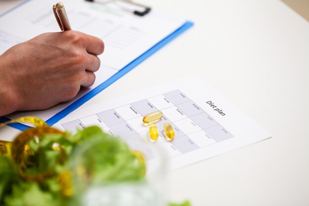 Foto treinador elabora um programa de treinamento e um plano de dieta saudável