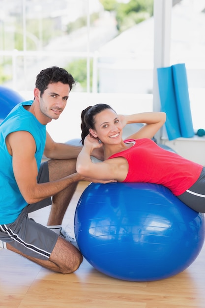 Treinador masculino que ajuda a mulher com seus exercícios