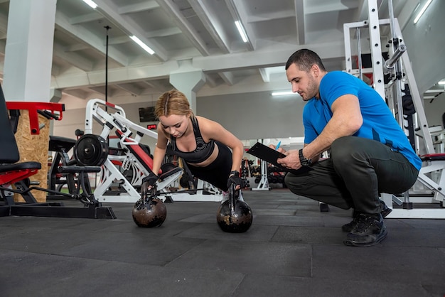 Treinador pessoal ajudando mulher magra fazendo exercícios no clube de saúde