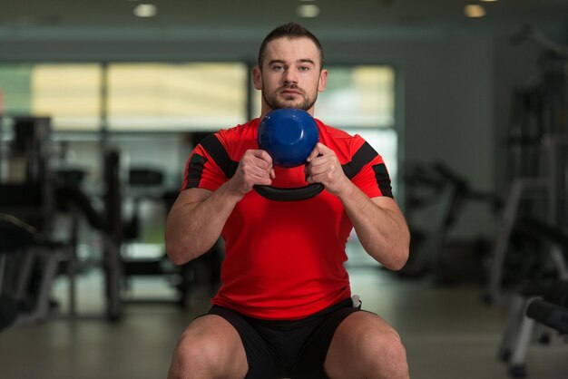 Foto treinador pessoal exercitando com kettlebell