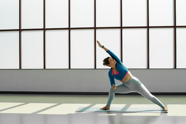 Treinadora feminina fazendo pose de ioga em um estúdio de aula de ioga