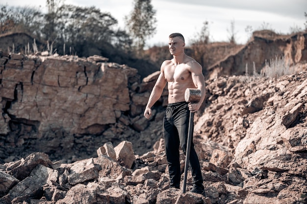 Treinamento ao ar livre do homem bonito sem merda atlético. Fisiculturista profissional demonstra seus músculos.