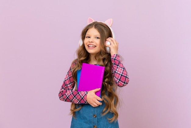 Treinamento de áudio em casa Uma garota com fones de ouvido está estudando material escolar