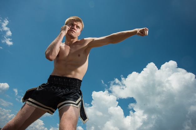 Treinamento de lutador masculino musculoso. boxer treina ao ar livre