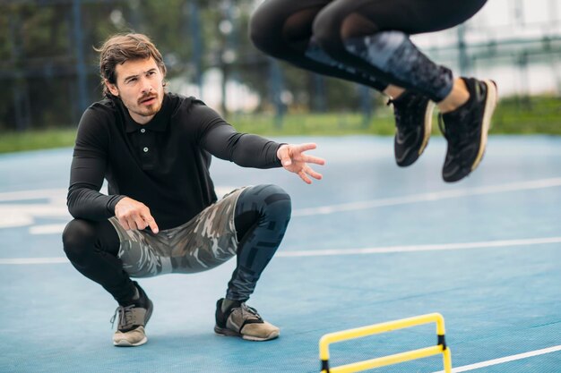 Foto treinamento de salto com treinador de fitness pessoal