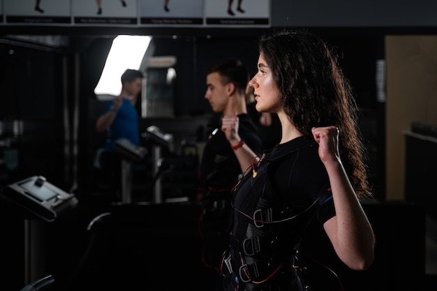 Treinamento em grupo EMS para dois homens e mulheres na academia