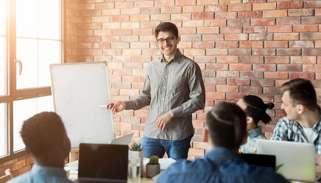 Foto treinamento em ti da empresa. homem de negócios alegre fazendo uma apresentação para um grupo masculino, copie o espaço