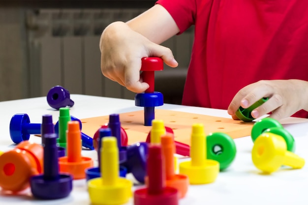 Treinamento Montessori Uma criança que brinca com cogumelos coloridos