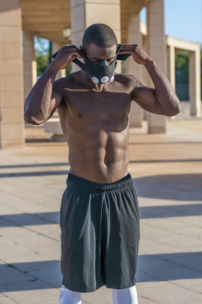 Treinamento muscular masculino com cordas de batalha e máscara de treinamento