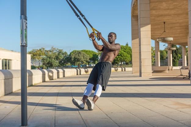 Treinamento muscular masculino com sistema trx