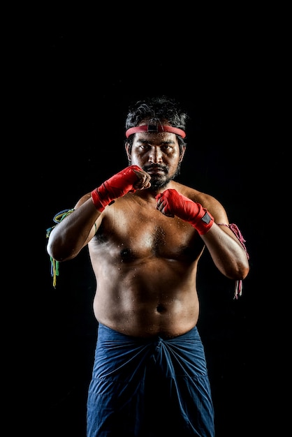 Treinamentos tailandeses do homem do pugilista de Muai. estúdio filmado em preto