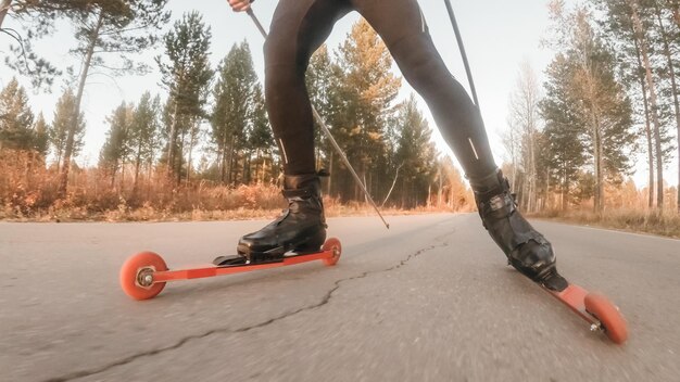 Foto treinando um atleta nos patinadores de patins passeio de biatlo nos esquis de patins com bastões de esqui