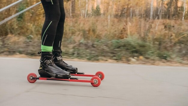 Treinando um atleta nos patinadores de patins Passeio de biatlo nos esquis de rolo com bastões de esqui no capacete Treino de outono Esporte de rolo