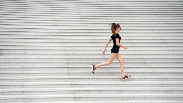 Treino ao ar livre. Mulher energética corre escadas ao ar livre. Vida ativa. Fique à vontade. Conceito de liberdade. Símbolo da liberdade. Viajar e viajar. Liberdade para explorar. Instrutor de fitness. Exercitando o espaço urbano.