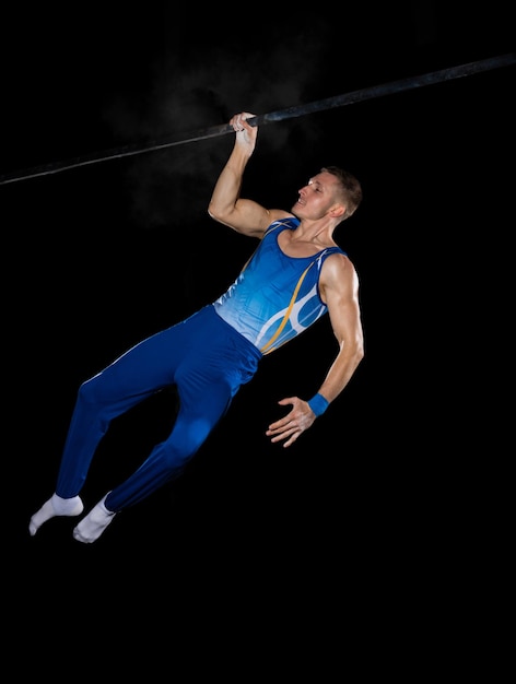 Treino de ginasta masculino musculoso em ginásio, flexível e ativo. Roupa esportiva masculina branca em forma