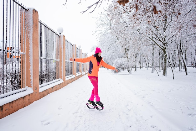 Treino de inverno exercitando-se em clima frio, fitness de inverno, kangoo salta mulher esportiva em