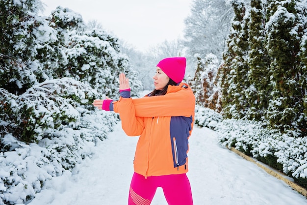 Treino de inverno fitness de inverno exercitando-se em esportista de clima frio fazendo exercícios de alongamento e