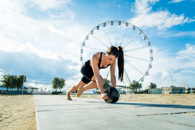 Treino funcional na praia, mulher em forma e atlética praticando esportes ao ar livre