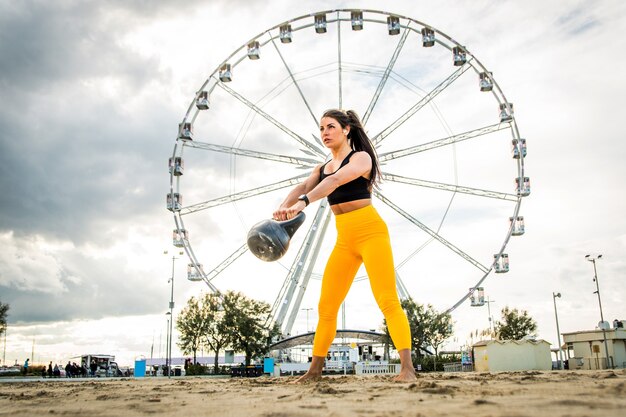 Treino funcional na praia, mulher em forma e atlética praticando esportes ao ar livre