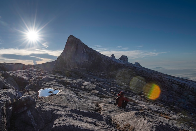 Trekker se sienta en la montaña Kinabalu con pico sur