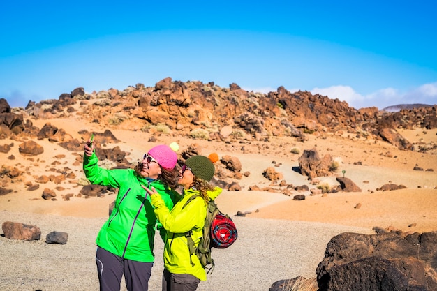 Trekking y actividad de personas de excursión de montaña al aire libre con dos amigas adultas tomando fotos selfie juntos divirtiéndose durante la caminata estilo de vida activo