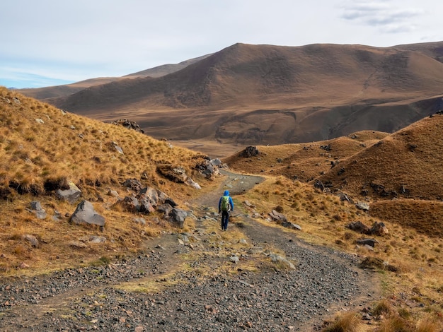 Trekking im Kaukasus Mann mit Rucksack klettert stark auf einem Bergpfad Abenteuer Solo-Reisen Lifestyle-Konzept aktiver Wochenendurlaub in der wilden Natur