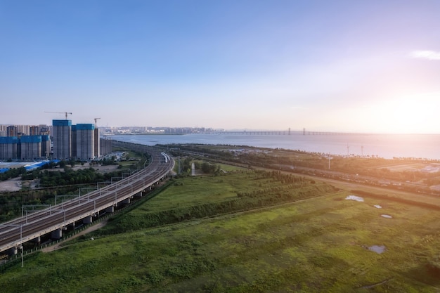Trem de alta velocidade passa pela ponte ferroviária na cidade chinesa moderna