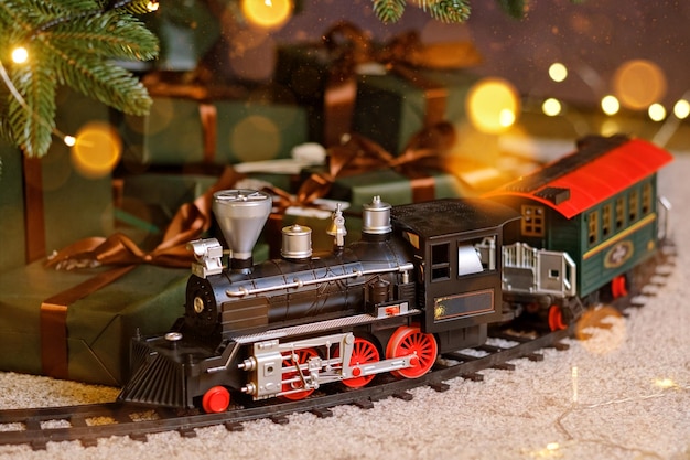 Foto trem de brinquedo embaixo da árvore de natal
