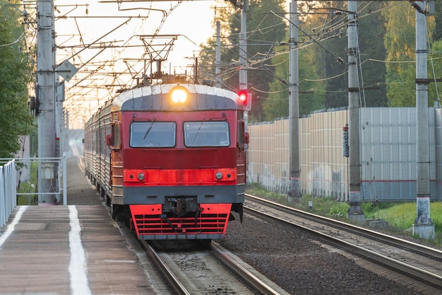 Trem elétrico suburbano chegando à estação de vagão de trem de passageiros chegando à plataforma vazia