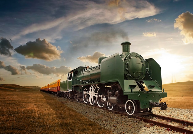 Trem em trilhos de trem contra o céu durante o pôr do sol