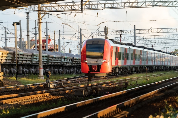 Trem intermunicipal moderno de alta velocidade ao pôr do sol no conceito de transporte suburbano comercial