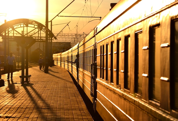 Trem saindo da estação ferroviária ao pôr do sol