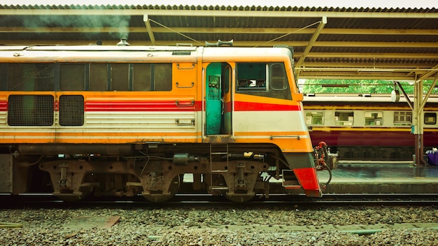 Trem velho diesel correndo para reconectar-se em uma plataforma da estação ferroviária Hua Lamphong em Bangkok