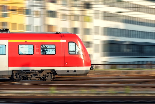 Trem vermelho de alta velocidade em movimento ao pôr do sol