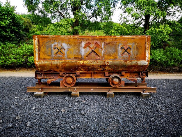 Foto tren abandonado en la vía del ferrocarril contra los árboles