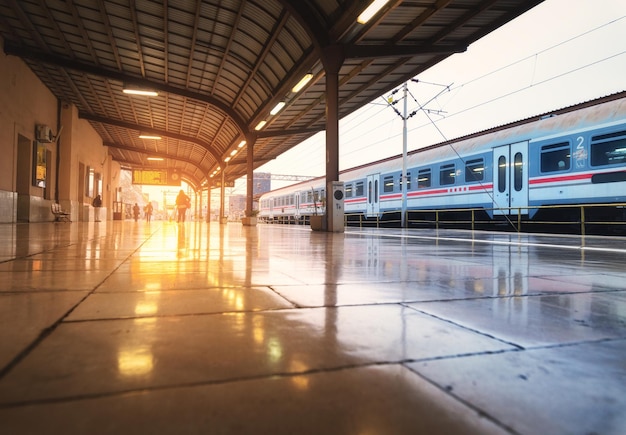 Tren de alta velocidad en la estación de tren al hermoso amanecer en Zagreb Croacia Tren de pasajeros interurbano moderno en la plataforma ferroviaria con la luz del sol reflejada en los azulejos Ferrocarril Transporte ferroviario