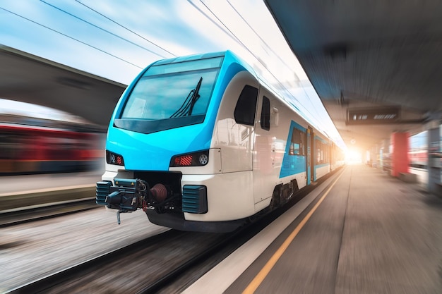 Tren azul de alta velocidad en movimiento en la estación de tren al atardecer Tren interurbano moderno rápido y fondo borroso Plataforma ferroviaria Ferrocarril en Eslovenia Transporte comercial y de pasajeros