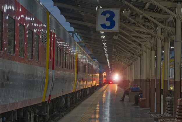 Un tren brillante en una plataforma con luz de puesta de sol en el fondo