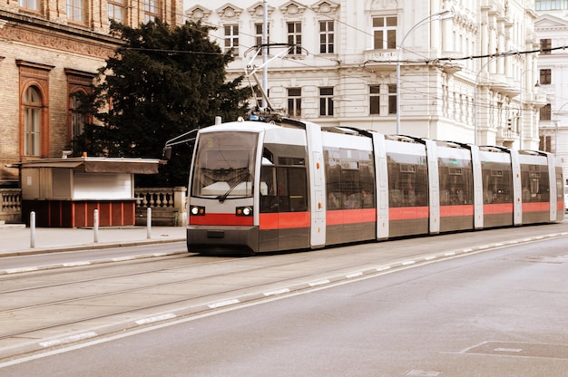 Un tren va por la calle frente a un edificio.