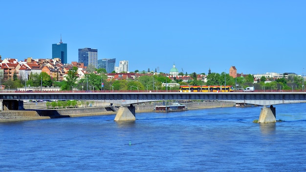 Foto un tren está cruzando un puente sobre un río y un puente está en el fondo