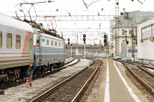 Un tren está en las vías frente a un edificio.